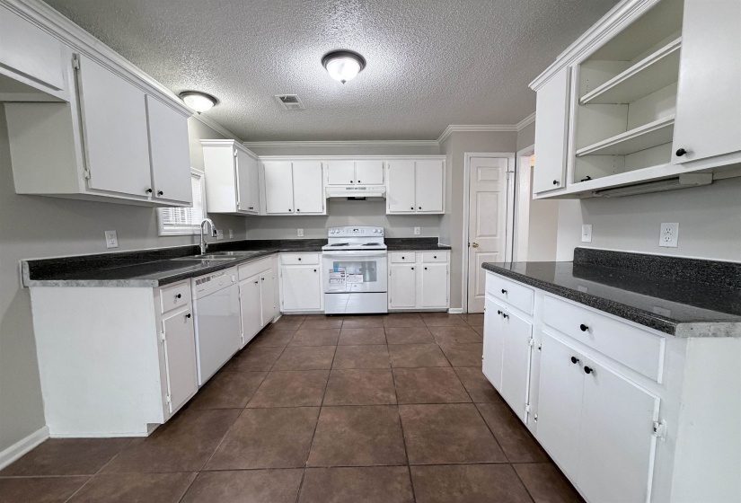 Kitchen with open shelves, white appliances, white cabinets, ornamental molding, and a textured ceiling