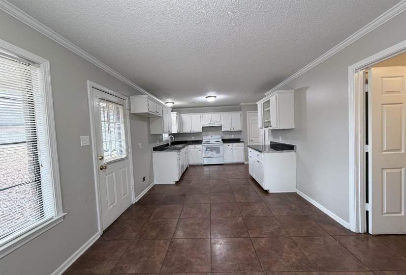 Kitchen featuring a textured ceiling, white cabinetry, crown molding, white electric range oven, and glass insert cabinets