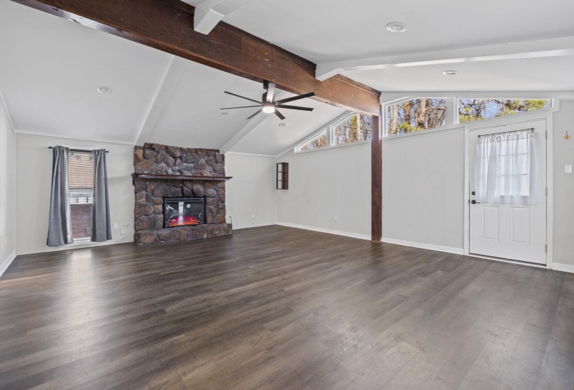 Unfurnished living room featuring a fireplace, dark wood-style flooring, and ceiling fan