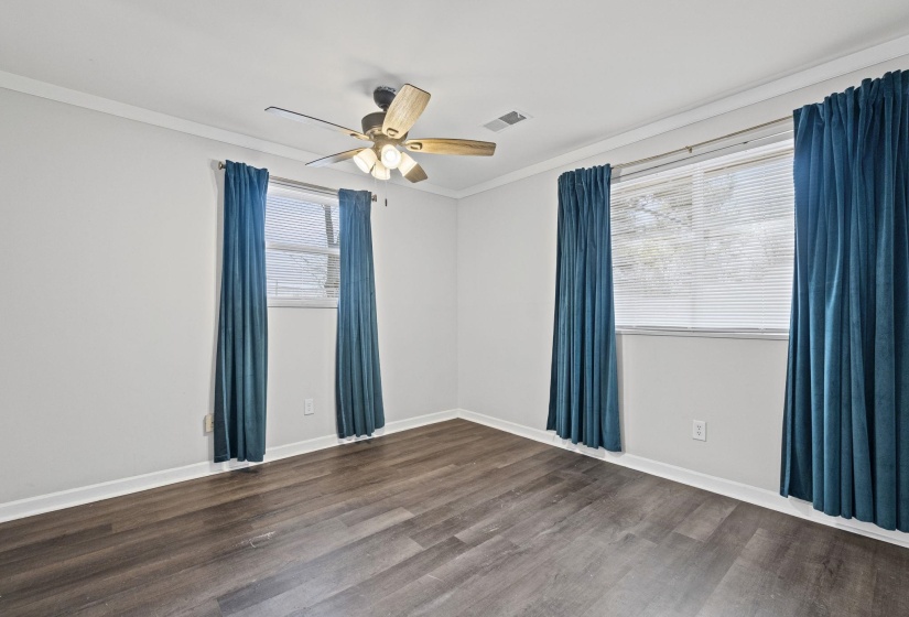 Unfurnished room with crown molding, dark wood finished floors, and ceiling fan