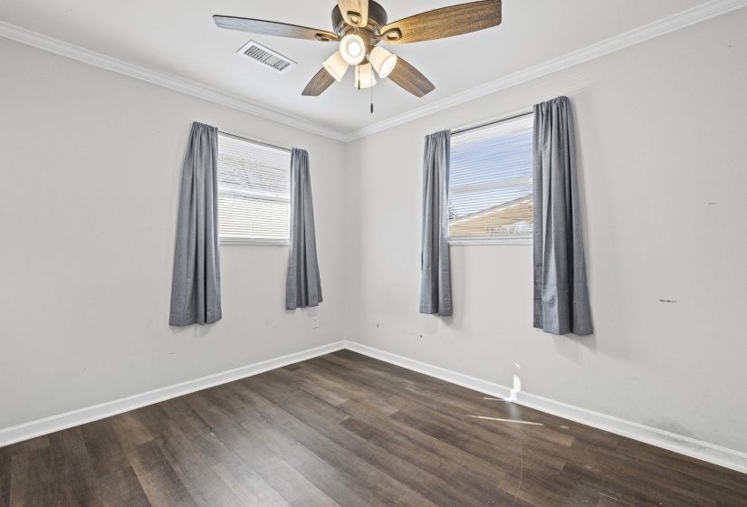 Spare room featuring ornamental molding, dark wood-style floors, and a ceiling fan