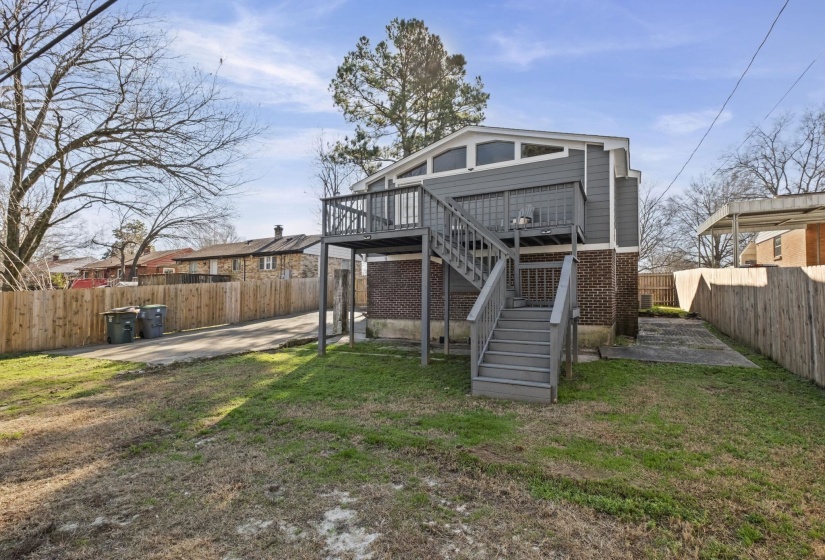 Back of property with a fenced backyard, stairway, a patio, a deck, and brick siding