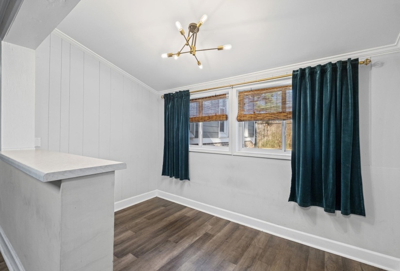 Empty room with a chandelier, crown molding, and dark wood finished floors