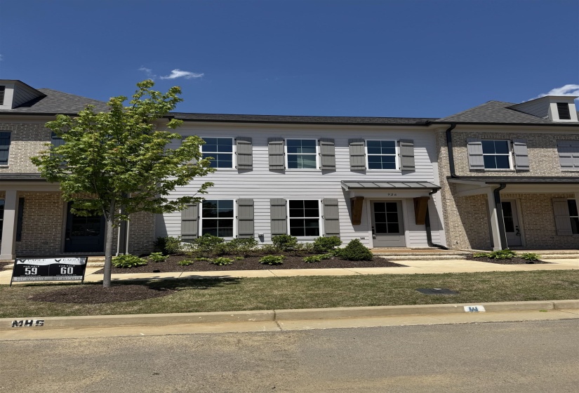 Contemporary townhome exterior featuring light gray siding, dark gray shutters, and a dark gray asphalt shingle roof