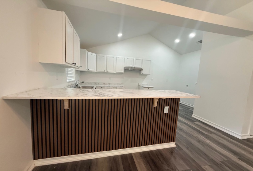 Kitchen island with a slatted wood-finish facade and light-toned countertop