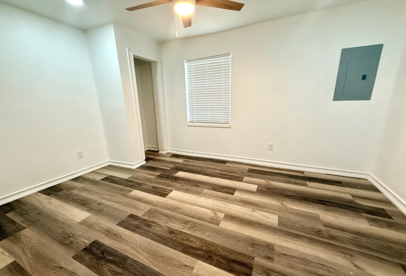 Room featuring wood-finish flooring, white baseboards, and a ceiling fan with integrated lighting