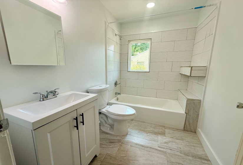Bathroom featuring a white vanity with black hardware, a rectangular sink, and a chrome faucet