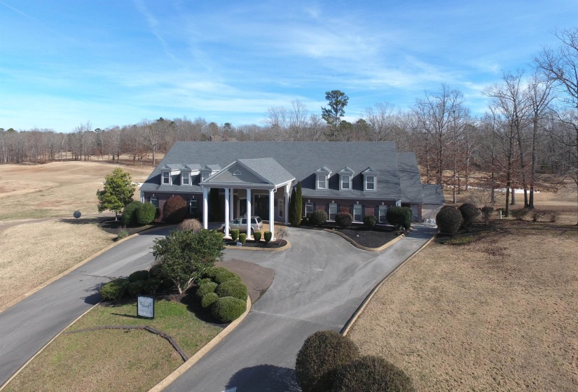 View of front of home featuring curved driveway, a front lawn, and a porch