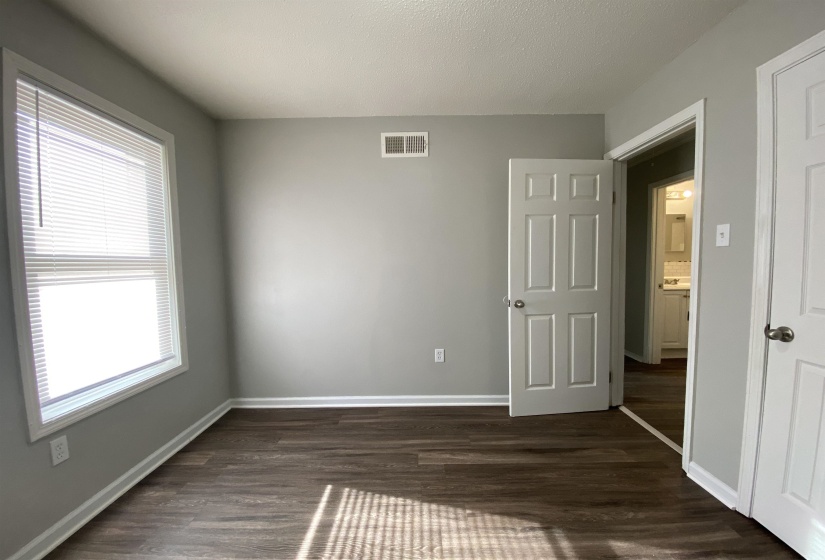 Unfurnished bedroom with dark wood-style flooring and a textured ceiling