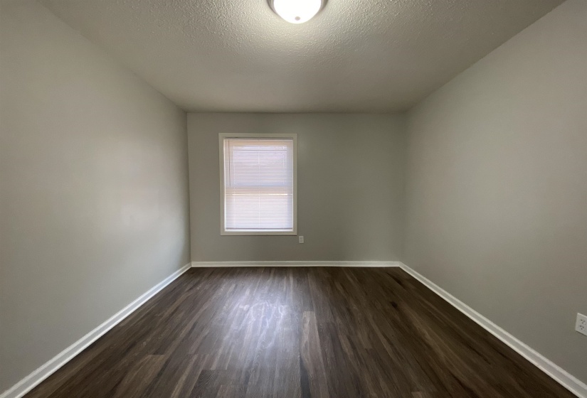 Spare room with dark wood-type flooring and a textured ceiling