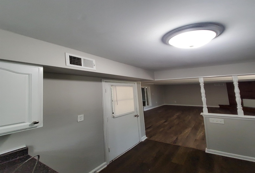 Modern interior with wood-finish flooring, light grey walls, and white trim