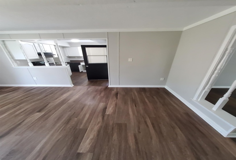 Spacious room featuring wood-finish flooring, light grey walls, and white trim