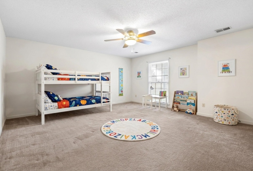 Spacious room featuring neutral carpeting, white wall finishes, and a multi-pane window
