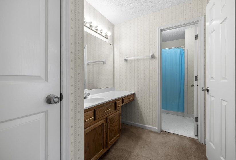 Bathroom vanity featuring a single sink, built-in cabinetry, and a wall-mounted mirror with overhead lighting