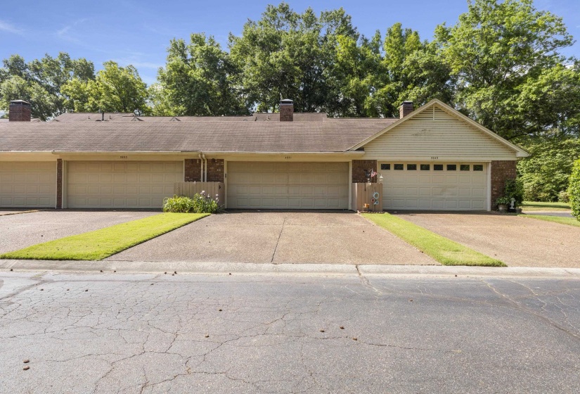 Attached multi-unit residential property featuring an asphalt shingle roof, brick and siding facade, and multiple garage doors