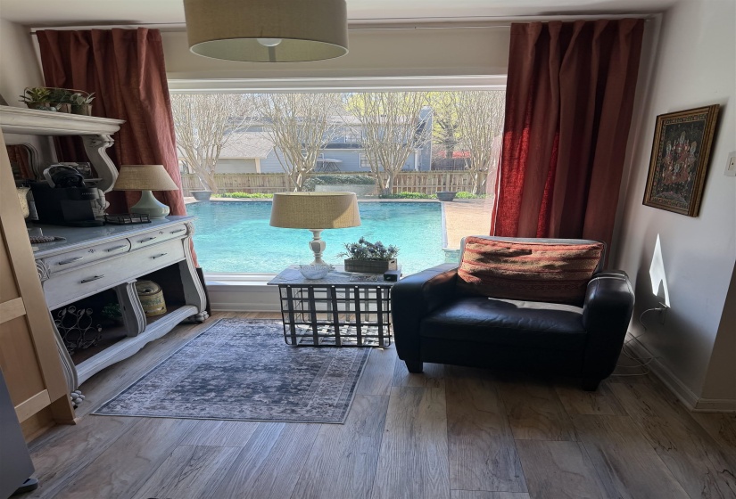 Expansive window overlooking a private swimming pool with surrounding brick paving