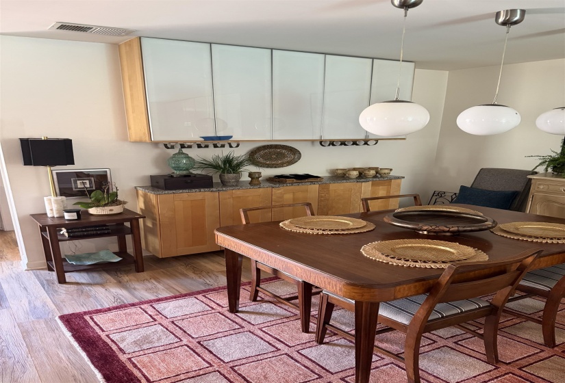 Dining area featuring wood-finish flooring and multiple pendant light fixtures