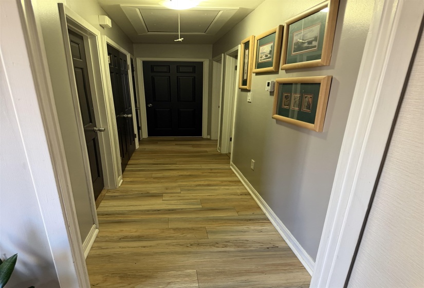 Hall with attic access and light wood-style flooring