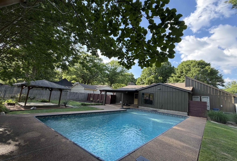 Rectangular swimming pool with a surrounding textured concrete patio
