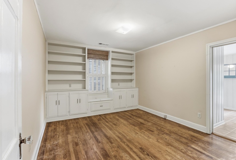 Built-in shelving with lower cabinetry and a window seat provides extensive storage