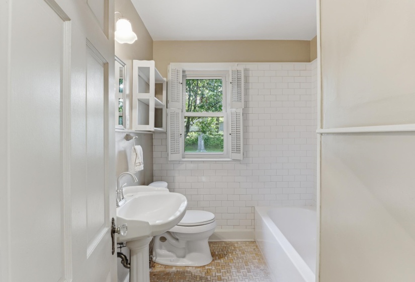 Full bathroom featuring subway tile surround, a pedestal sink, and a built-in bathtub