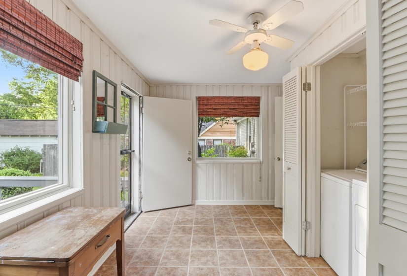Versatile sunroom featuring tile flooring, white vertical plank walls, and multiple windows with woven blinds