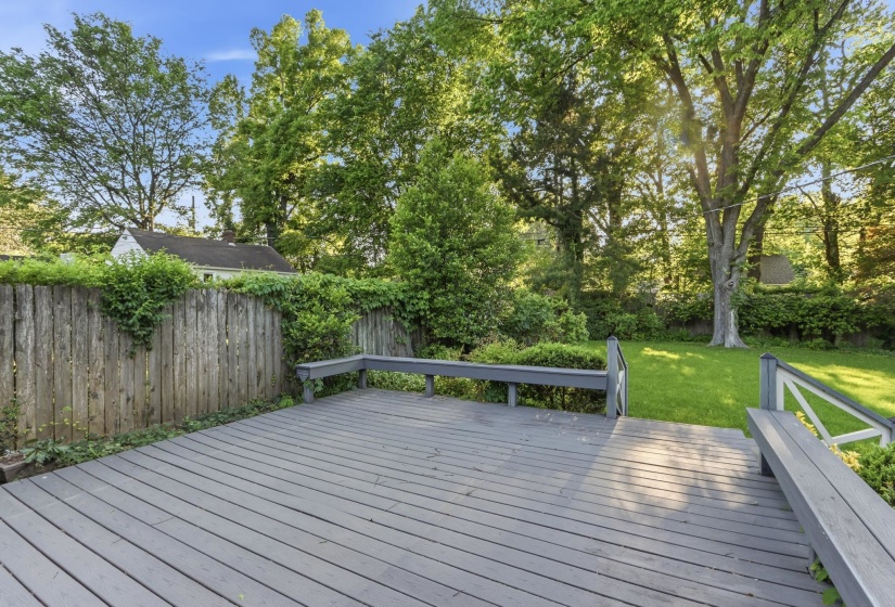 Spacious outdoor deck with painted wood-finish flooring, integrated railing, and built-in bench seating