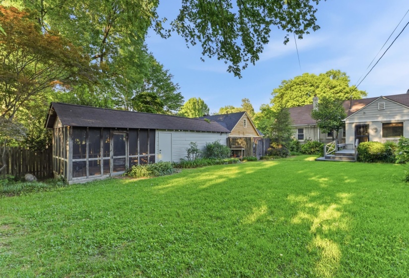 Expansive lawn area with a screened structure and a detached storage building