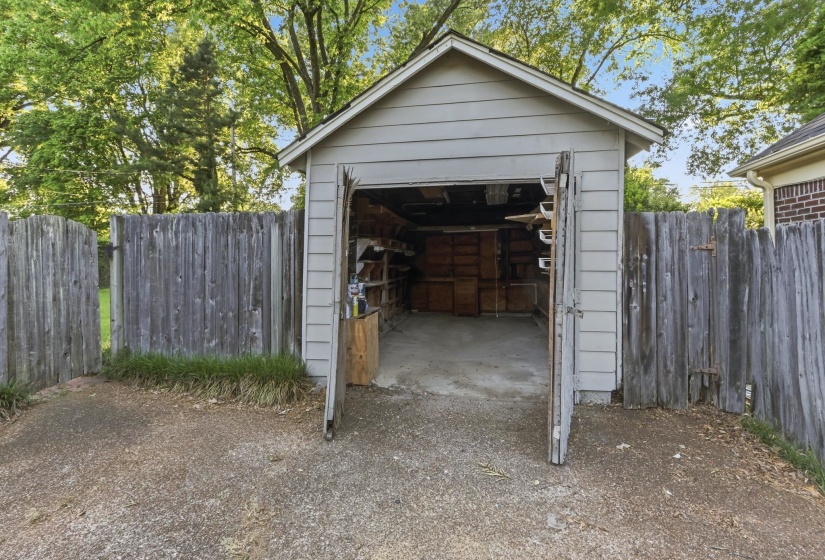 Detached garage featuring panel siding and a gabled roofline