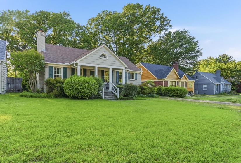 Traditional-style residence featuring a prominent front porch, exterior shutters, and a brick chimney