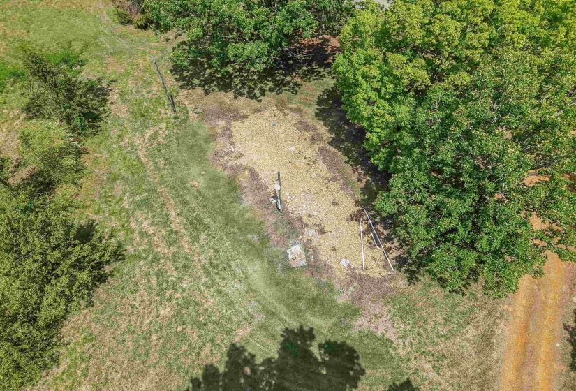 Expansive lot featuring a mix of mature trees and open grassy areas, with a dirt path bordering the property