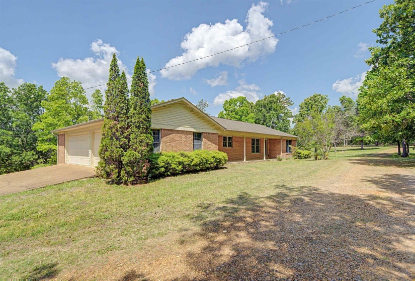 Brick exterior featuring a covered front porch and an attached two-car garage