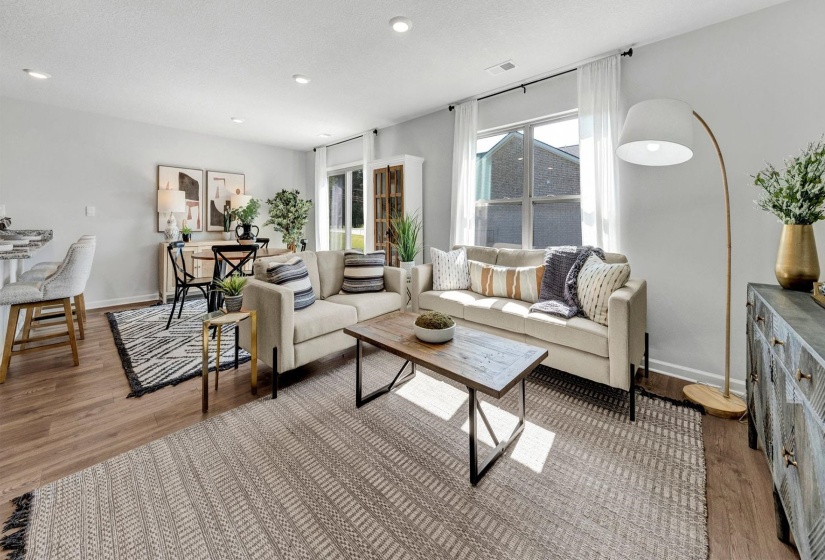 Living area featuring light wood-style flooring, a textured ceiling, and recessed lighting