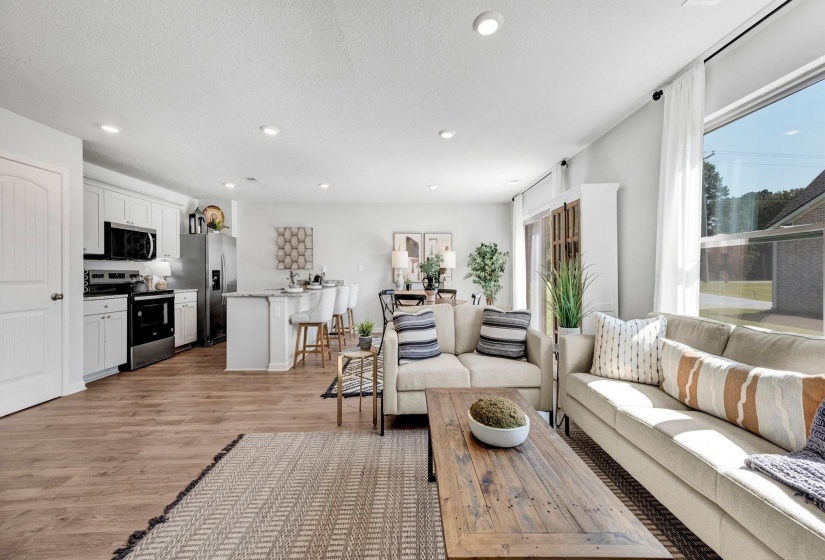 Living room featuring light wood-style flooring, recessed lighting, and a textured ceiling