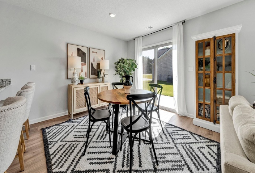 Dining area with light wood-type flooring and a textured ceiling