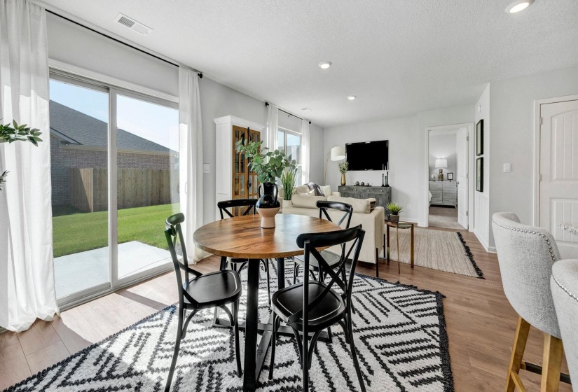 Dining room with light wood-style floors, a textured ceiling, and recessed lighting