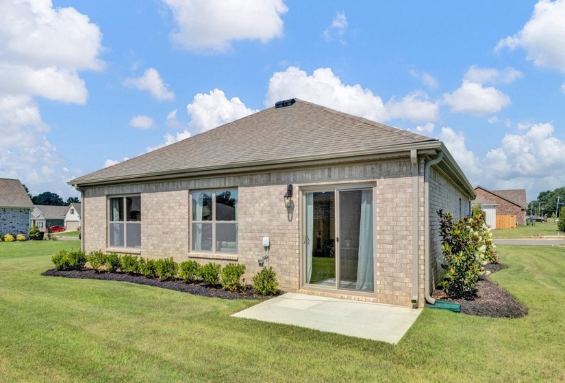 Rear view of property featuring a lawn, brick siding, and roof with shingles
