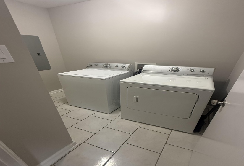 Dedicated laundry area featuring tile flooring and light gray wall paint
