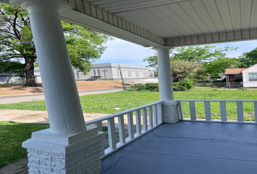 Front porch featuring white columns and a painted concrete floor