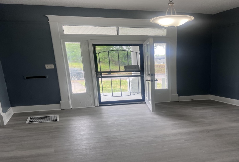 Entryway featuring wood-finish flooring, dark wall paint, white trim, and a semi-flush mount ceiling fixture
