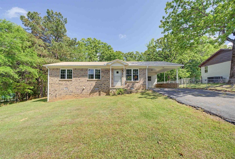 Brick exterior residence featuring a front entry porch, a metal roof, and a covered carport