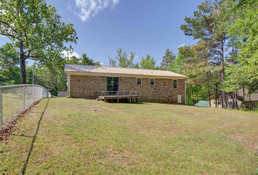 Brick exterior with a metal roof and a rear wooden deck