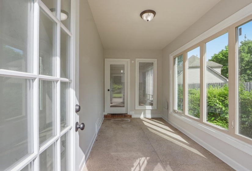 Sunroom with floor-to-ceiling windows, light beige wall paint, a frosted glass paneled door, and a flush-mount ceiling light fixture