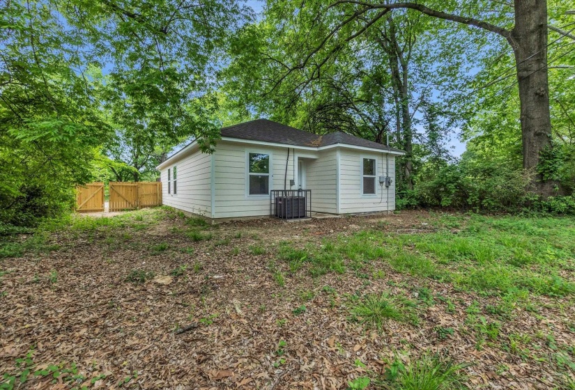 White siding exterior featuring a dark shingle roof, multiple windows, and a side-mounted HVAC unit