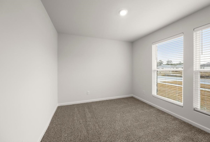 Unfurnished room featuring baseboards and dark colored carpet