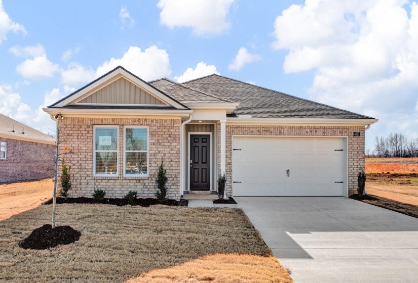 Ranch-style home featuring brick siding, a garage, driveway, and roof with shingles