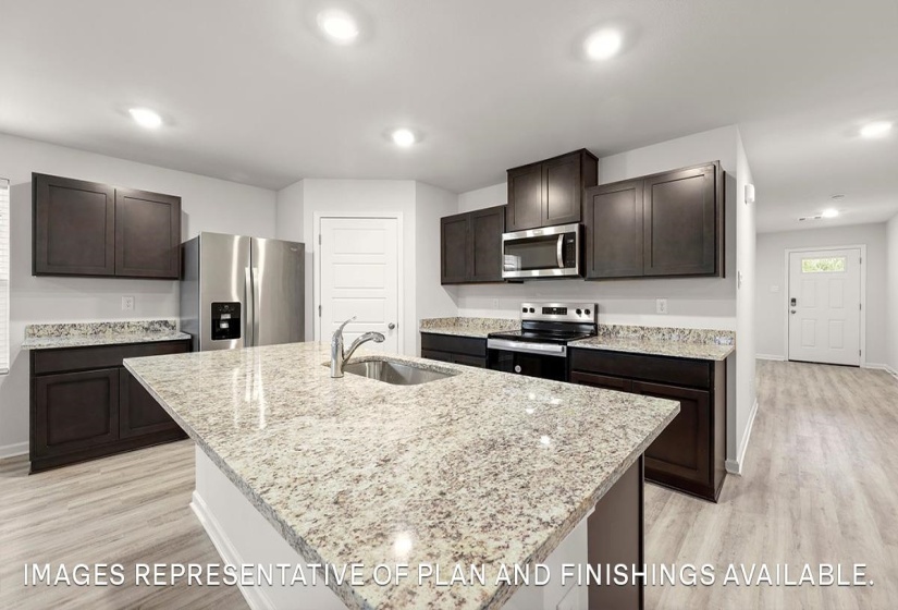 Kitchen featuring stainless steel appliances, light stone counters, light wood-style flooring, recessed lighting, and dark wood finish cabinetry