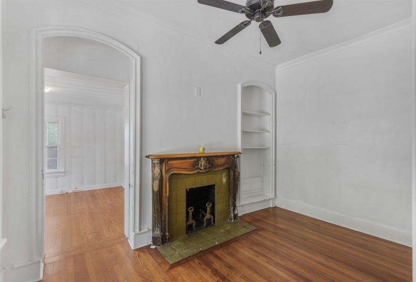 Hardwood flooring throughout, featuring an ornate fireplace with tiled surround and hearth