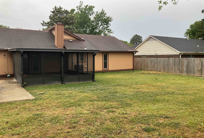 Screened-in porch featuring a concrete patio, directly accessing the expansive grassy backyard