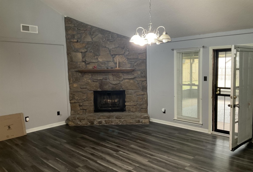 Stone fireplace with hearth and wood mantel